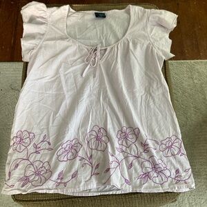 Light pink blouse with purple embroidery.